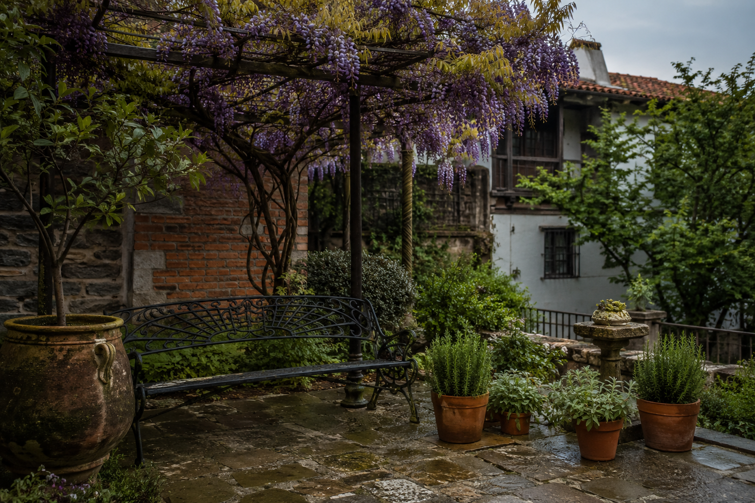 Patio cantabro con pergola de glicinia y bancos de hierro forjado